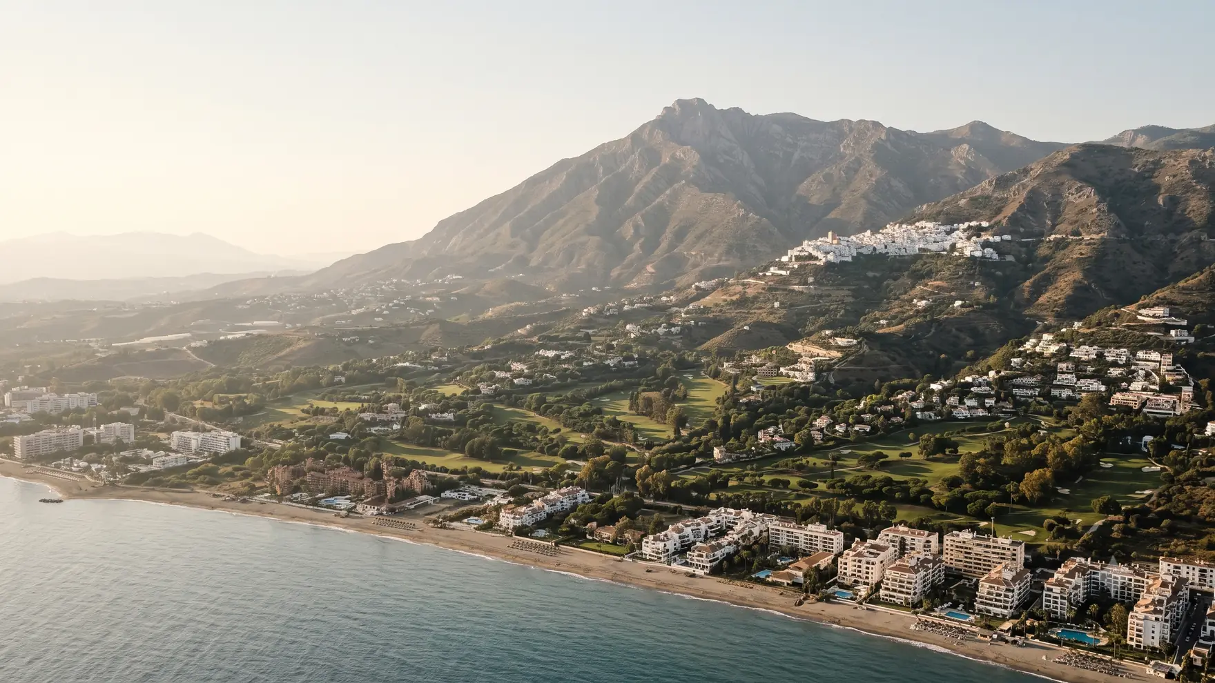 The Mijas landscape rising from the beachfront apartments through the golf valley to the white village high on the Sierra de Mijas
