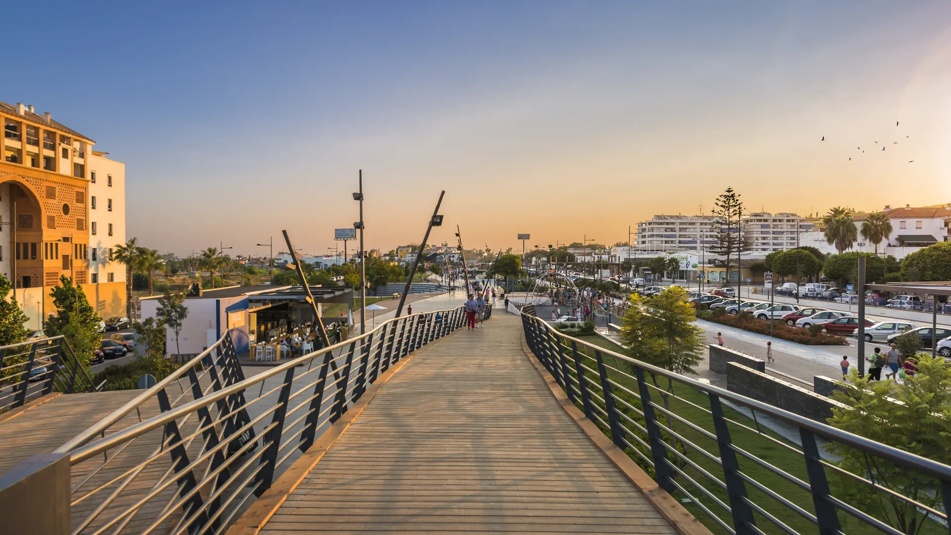 The landmark pedestrian bridge on the revitalised boulevard in San Pedro Alcantara, with the town going about ordinary daily life