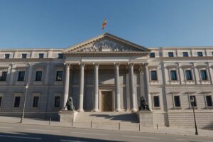 Neoclassical parliament building in Madrid with columns, bronze lions and the Spanish flag